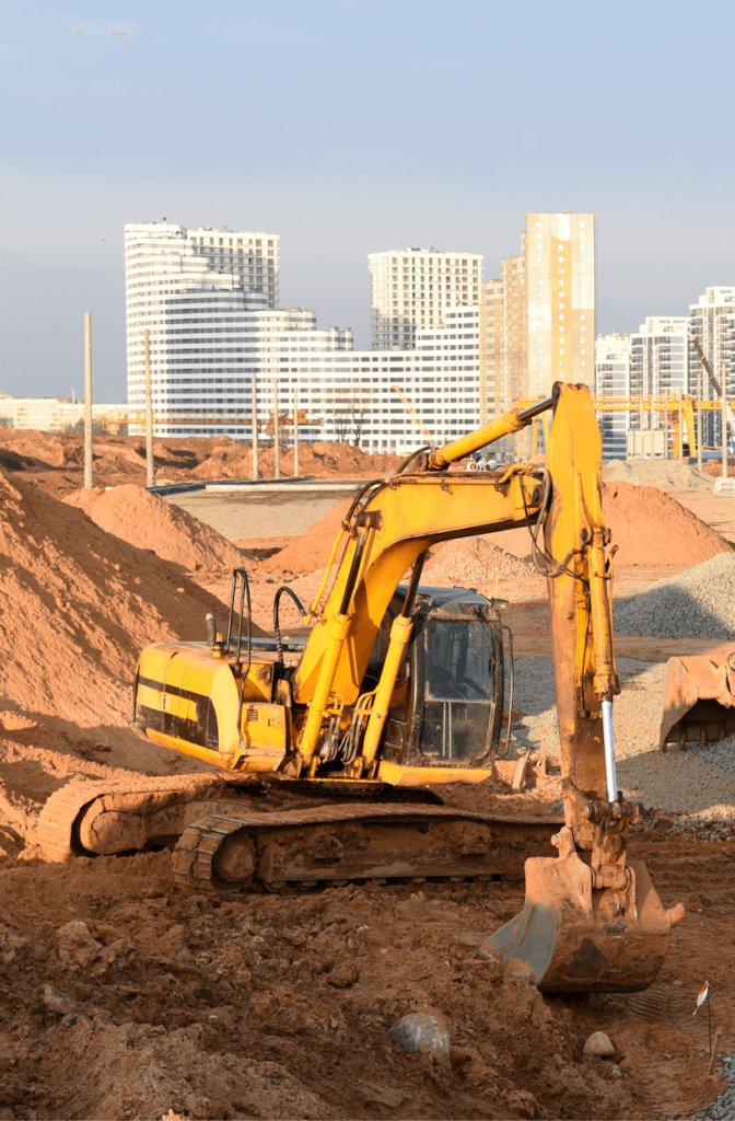 Excavator working on dig ground trenching at construction site.